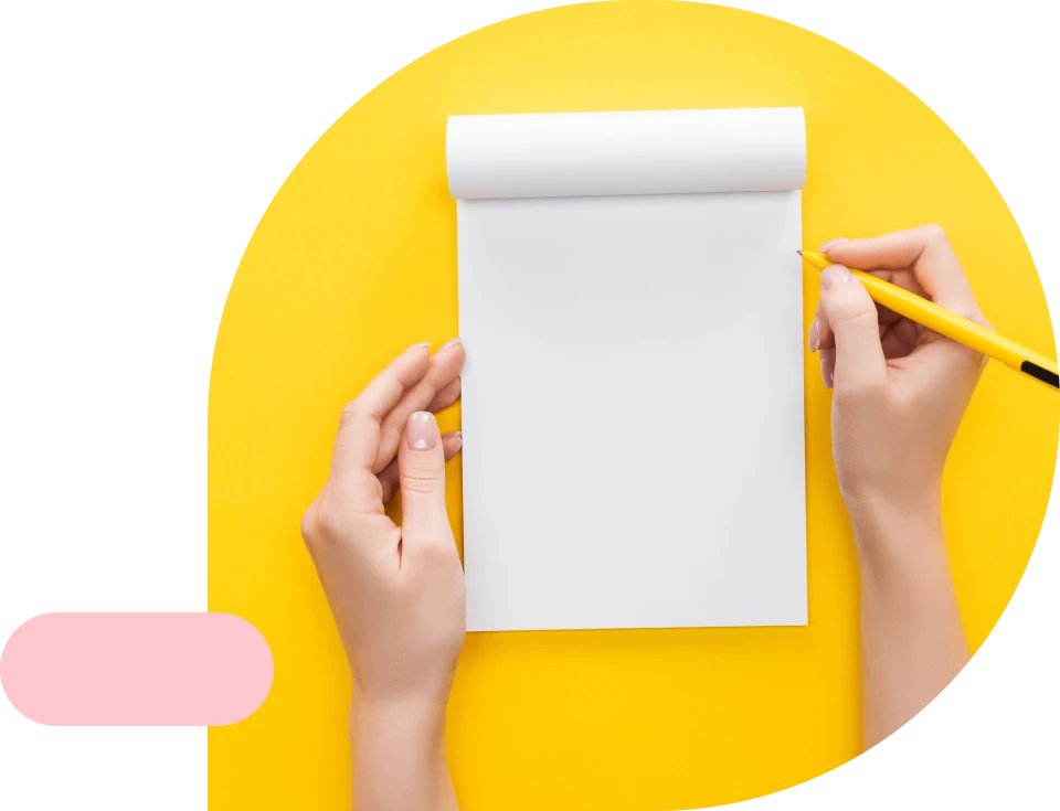 A yellow notebook and pen, styled on a desk